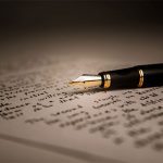 A pen sitting on top of an open book.