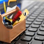 A wooden toolbox with tools sitting on top of it.